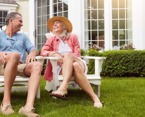couple de jeunes retraités assis dans leur jardin