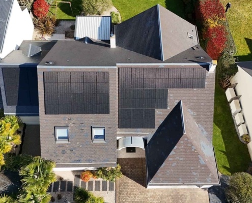 Vue aérienne de face d'une installation de panneaux photovoltaïques sur la toiture d'un particulier