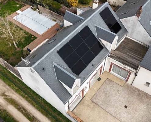 Vue aérienne de côté d'une installation de panneaux photovoltaïques sur la toiture d'un particulier