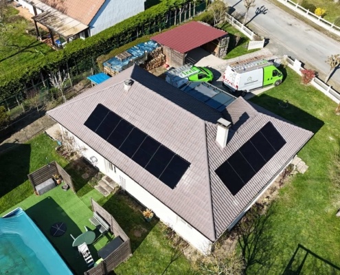 Vue aérienne de côté d'une installation de panneaux photovoltaïques sur la toiture d'un particulier, répartis sur deux façades