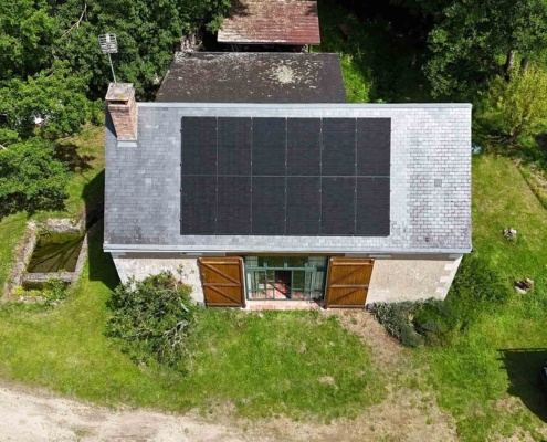 Vue aérienne du dessus d'une installation de 12 panneaux photovoltaïques sur la toiture d'un particulier.